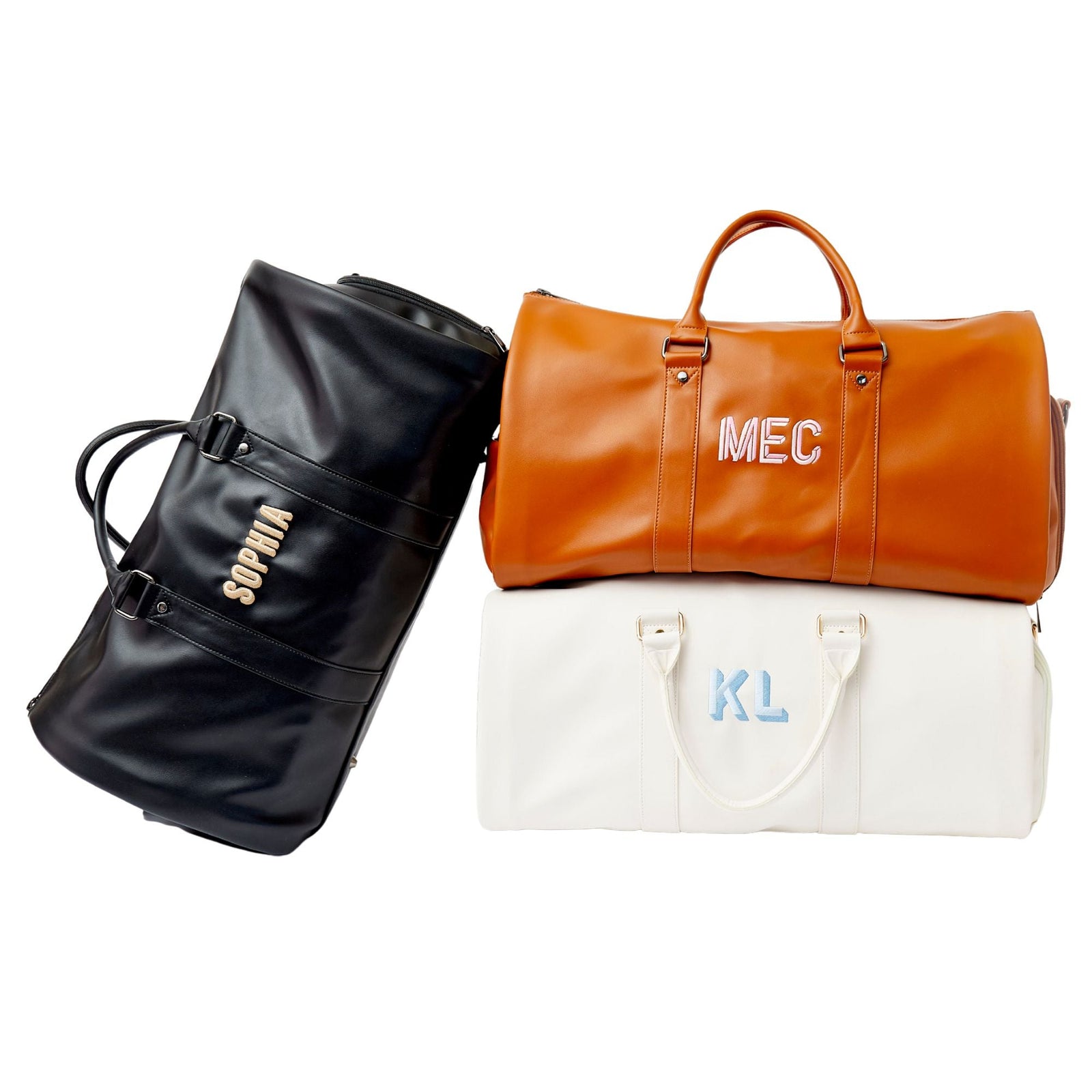 A white, tan, and black duffel are personalized with embroidery.