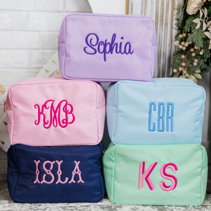 A group of a extra large nylon pouches are customized with embroidered monograms and names