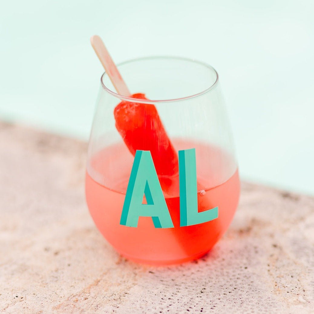 Three wine glasses with different colored shadow monograms