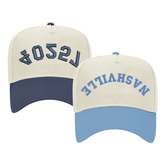 Image of two baseball caps, each featuring a different color scheme and text. The left cap has a cream crown with a navy blue bill and displays the word '75204' in navy thread, embroidered in a stylized font. The right cap has a cream crown with a light blue bill and shows the word 'NASHVILLE' in blue thread, also in a stylized font. Both caps have a structured design with adjustable snaps at the back.