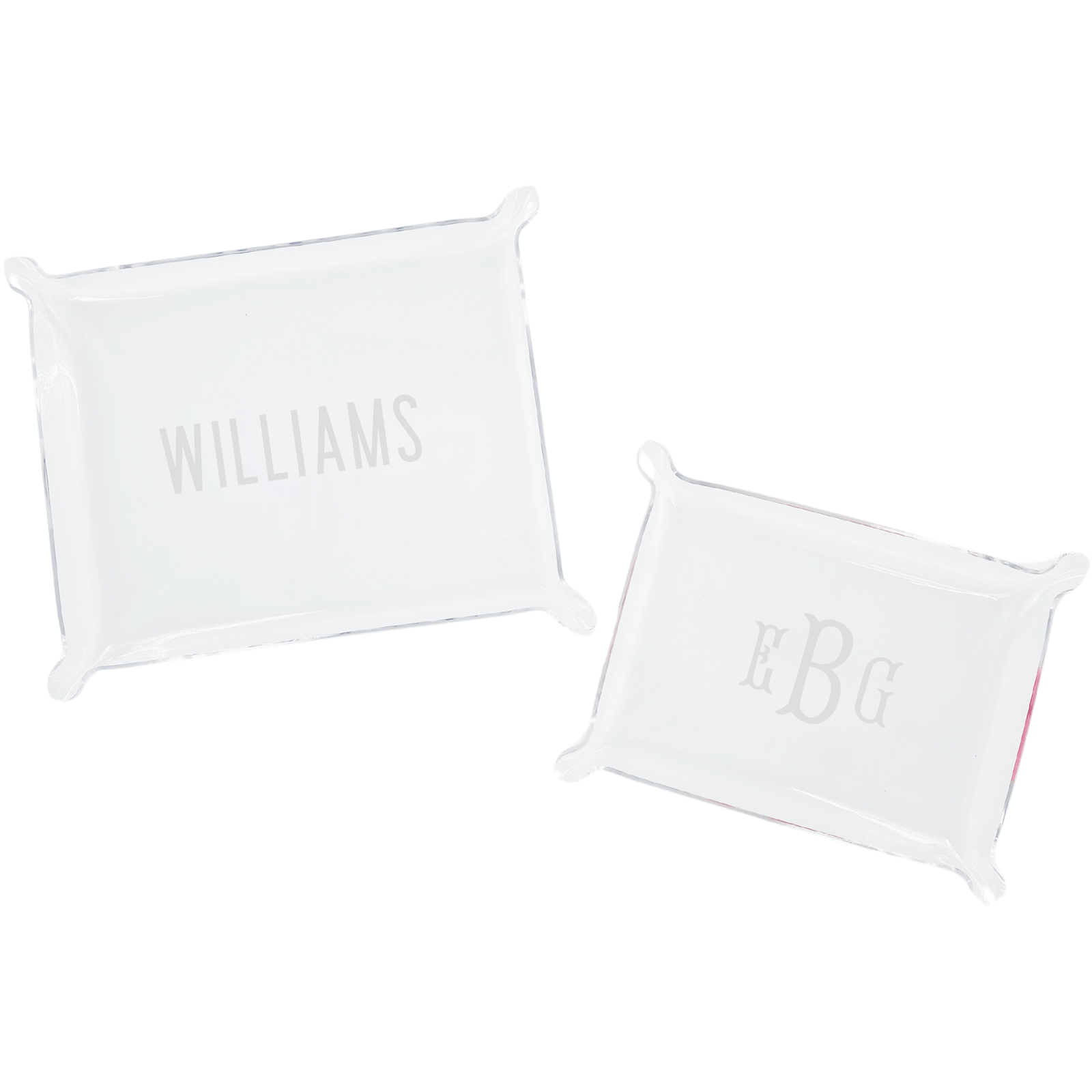 A set of two personalized acrylic trays featuring elegant monogrammed designs—one with the name 'WILLIAMS' and the other with initials 'EBG.' These chic and versatile catch-all trays add a stylish touch to any space, perfect for organizing small essentials on a desk, dresser, or entryway. Pair them with other custom acrylic accessories for a coordinated look